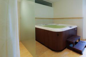 a bathroom with a bath tub and a wooden stool at Apartment Hotel Christine in Avelengo +96 photos