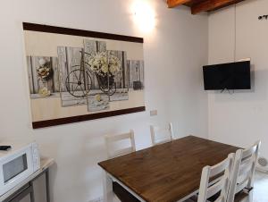 a dining room with a table with chairs and a tv at Fattoria Cristina - Bilo Verde in Castelnuovo Magra