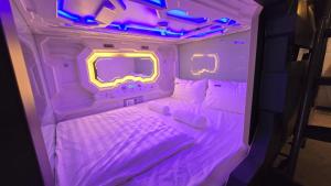 a bed in a room with purple lights at Space Hotel KL Sentral in Kuala Lumpur