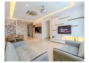 a living room with couches and a tv on a wall at Setapak Central Premium Suites in Kuala Lumpur