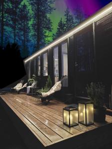 アカスロンポロにあるLapland Riverside Cabin 4 HILLA , Ylläs, Tiny Home with Sauna, Fireplace, Terrace, BBQ, Wifi, Ski, Fishing, Pets OKの建物内のデッキ(椅子、照明付)
