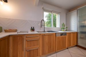 a kitchen with wooden cabinets and a sink at Petit appartement in Saint-Gildas-de-Rhuys