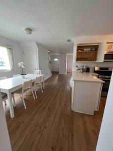 una cucina e una sala da pranzo con tavolo e sedie bianchi di Beach House 2Car parking Beach Subway City JFK USB a Edgemere