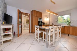 a kitchen with a table and chairs and a tv at Petit appartement in Saint-Gildas-de-Rhuys