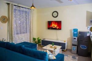 a living room with a blue couch and a fireplace at Derosa Homes Figtree Apartment 2bdrm in Tezo