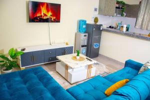 a blue couch in a living room with a fireplace at Derosa Homes Figtree Apartment 2bdrm in Tezo