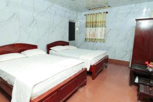 Dos camas en una habitación con paredes azules. en Thanh Nhàn 1 Hotel Cà Mau - by BAYLUXURY, en Xóm Lơn