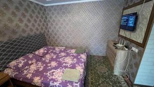 a small bedroom with a bed and a tv at Eles2 in Karakol