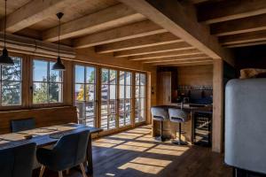a kitchen with a table and chairs and windows at Chalet Javorka in Kořenov