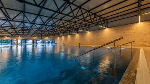 a large swimming pool with blue water in a building at FM mobile - Oaza mira, Drage in Drage