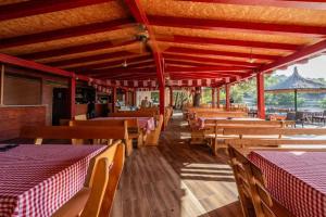 a restaurant with wooden tables and chairs with red and white tables at FM mobile - Oaza mira, Drage in Drage