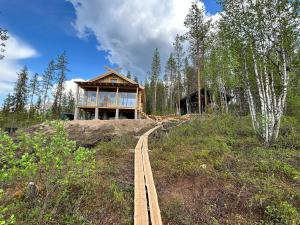 a house on top of a hill with a train track at Lapland Riverside Cabin, Äkäsjoki Hideaway - Riverview, Traditional Sauna, Avanto, WiFi, Ski, Ylläs in Äkäsjoensuu