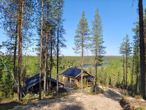 a log cabin in the middle of a forest at Lapland Riverside Cabin, Äkäsjoki Hideaway - Riverview, Traditional Sauna, Avanto, WiFi, Ski, Ylläs in Äkäsjoensuu +43 photos