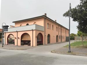 a large building with arches on the side of a road at Al Gallo Trattoria e Locanda in Alfonsine
