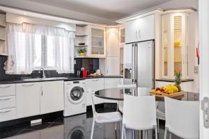 une cuisine avec des armoires blanches et une table et des chaises dans l'établissement Villa Funchal bay view, à Funchal 23 autres photos