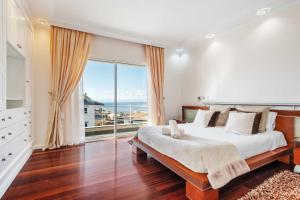 une chambre avec un grand lit et une grande fenêtre dans l'établissement Villa Funchal bay view, à Funchal