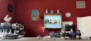 a red room with a bar with a liquor cabinet at Al Gallo Trattoria e Locanda in Alfonsine +16 photos