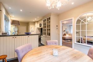 eine Küche und ein Esszimmer mit einem Holztisch und Stühlen in der Unterkunft The Cozy Cottage in Eeklo + 12 Fotos