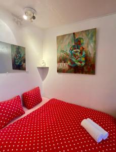 a red bed in a room with two paintings at Studio chic Paris Tour Eiffel Near Eiffel tower 7th floor in Paris