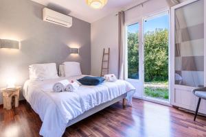 Un pat sau paturi într-o cameră la Sòle - Peri - Maison climatisée avec piscine