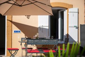 a table and chairs with an umbrella next to a building at La Maison du Parc in Digoin