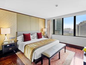 a bedroom with a large bed and a large window at Mandarin Oriental, Jakarta in Jakarta