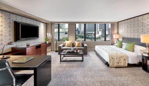 a hotel room with a large bed and a living room at Mandarin Oriental, Jakarta in Jakarta