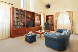 a living room with a blue leather couch and a table at Villa Diocletian's Palace in Supetar