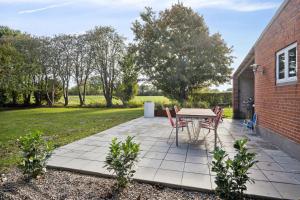 a patio with a table and chairs next to a brick building at Renovated Home In Rural Idyll, Close To The Beach in Haderslev