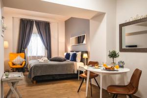 a bedroom with a bed and a table and chairs at D&A Amphitheatre Apartments with free parking in Pula