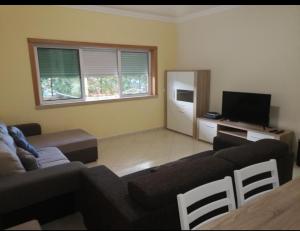 a living room with a couch and a flat screen tv at Espírito Santo Apartament in Portimão
