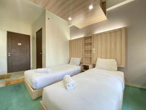 ein Schlafzimmer mit zwei Betten mit weißer Bettwäsche in der Unterkunft Beauty Studio No Kitchen at Easton Park Residence Jatinangor Apartment By Travelio in Sumedang