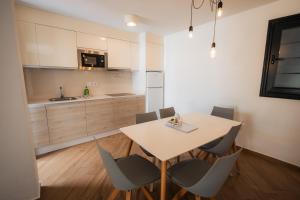 a kitchen and dining room with a table and chairs at Los Cardones Boutique Village in Playa de las Americas