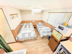 a small room with three beds and a tv at SHINJUKU WARM VILLA I in Tokyo +37 photos