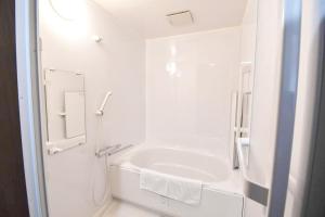 a white bathroom with a tub and a sink at SHINJUKU WARM VILLA I in Tokyo