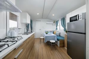 a kitchen with a refrigerator and a table in it at Albatross Mobile Homes on Camping Bijela Uvala in Poreč
