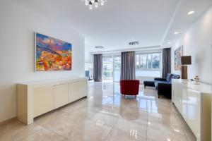 a living room with a painting on the wall at St Georges Bay Oasis Steps from the Beach in St. Julianʼs