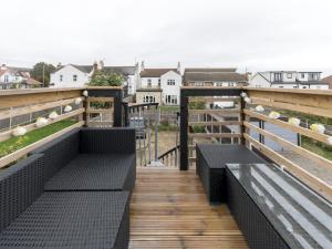two benches on a wooden deck with a view of the ocean at Pass the Keys Cosy Flat in Leigh Sea View in Southend-on-Sea
