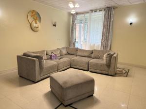 una sala de estar con un sofá y un taburete en Mont Goma, en Goma