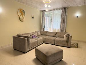 sala de estar con sofá y reposapiés en Mont Goma, en Goma