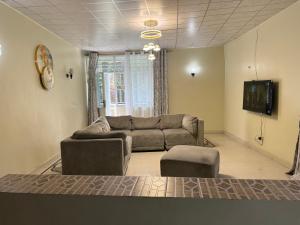 Una sala de estar con un sofá y un televisor. en Mont Goma, en Goma