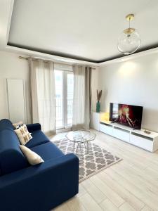 a living room with a blue couch and a tv at Appartement proximité Strasbourg in Lingolsheim