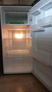 - un réfrigérateur vide avec une porte ouverte dans l'établissement Villa Naga, pool, Kitchen, terace and garden, à Kerobokan