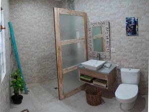 une salle de bain avec toilettes, lavabo et miroir dans l'établissement Villa Naga, pool, Kitchen, terace and garden, à Kerobokan
