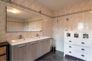 ein Badezimmer mit einem weißen Waschbecken und einem Spiegel in der Unterkunft The Cozy Cottage in Eeklo