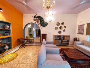 Una sala de estar con sofás y una lámpara de araña. en Arka Luxury Homestay, en Jaipur
