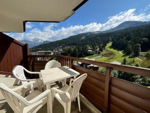Ein Tisch und Stühle auf einem Balkon mit Aussicht in der Unterkunft Résidence Atrey 403 Clés Blanches Courchevel in Courchevel
