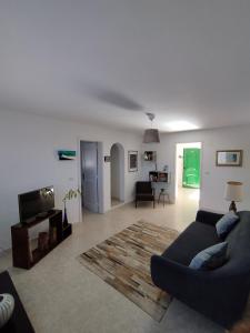 a living room with a couch and a tv at Vivienda Vacacional Casa del Erizo - Ecofinca in Nazaret