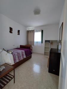 a bedroom with a bed and a table and a window at Vivienda Vacacional Casa del Erizo - Ecofinca in Nazaret +37 photos