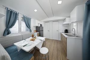 a small kitchen with a white table and a sink at Albatross Mobile Homes on Camping Laguna Village in Porto Falconera